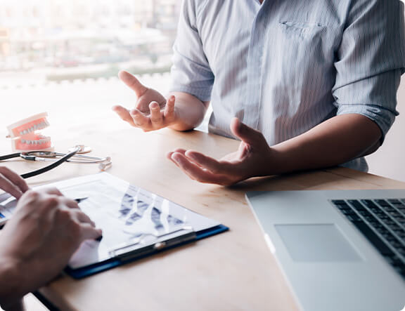 man's hands expressing a conversation at a table