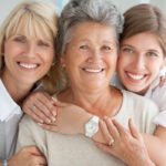 3 generations of women smile together, one with a Snap-On Smile in San Antonio, TX