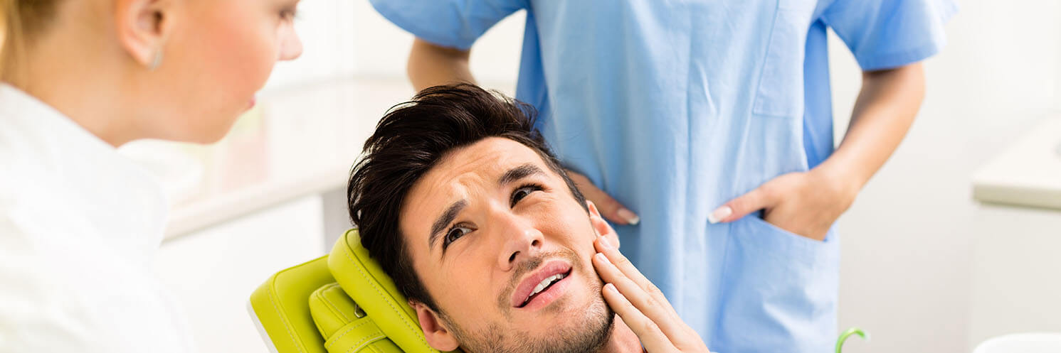 Man dealing with emergency tooth pain