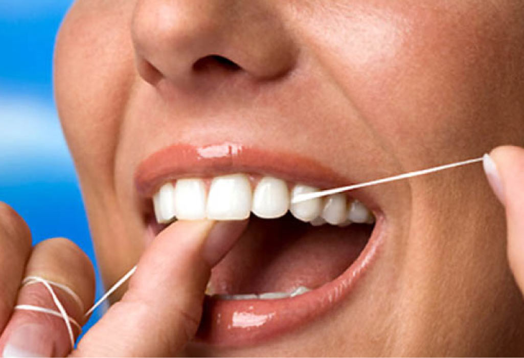 close up of a woman flossing her teeth