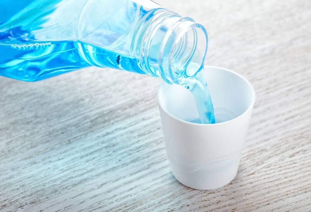 mouthwash being poured into a small cup to fight bad breath