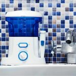 water flosser sitting on a bathroom counter next to the sink