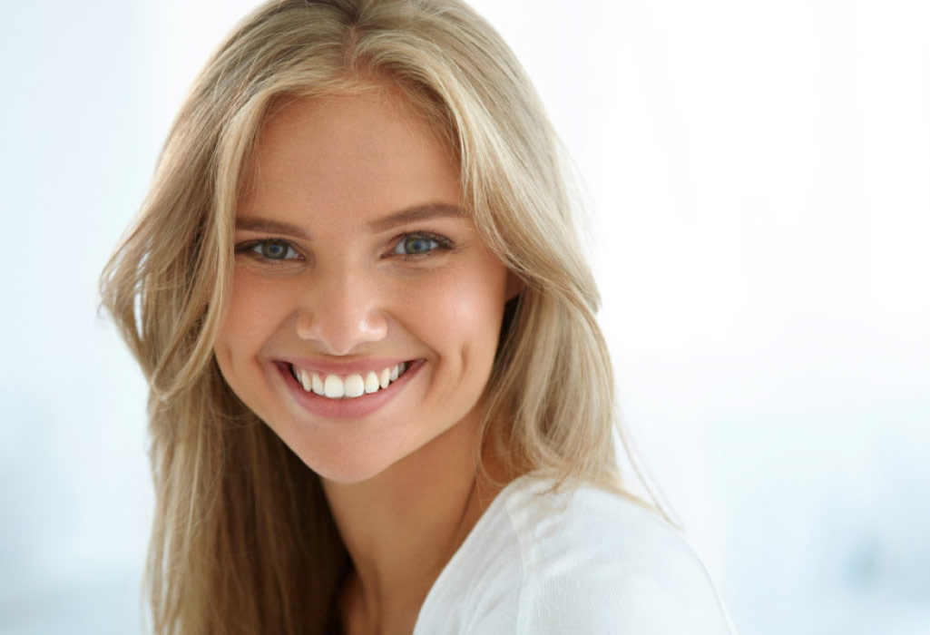 young blond woman flashes a bright white smile