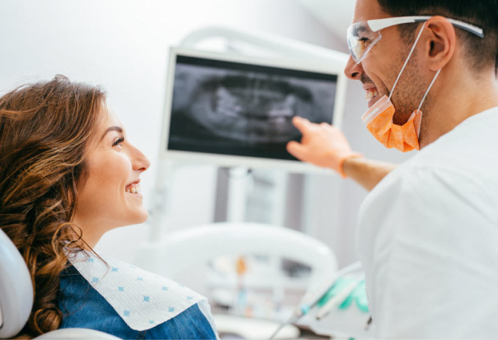 female dental patient looks at her dental x-rays with the dentist