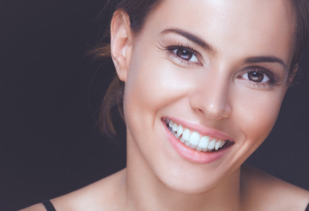 young woman smiles showing off her white teeth