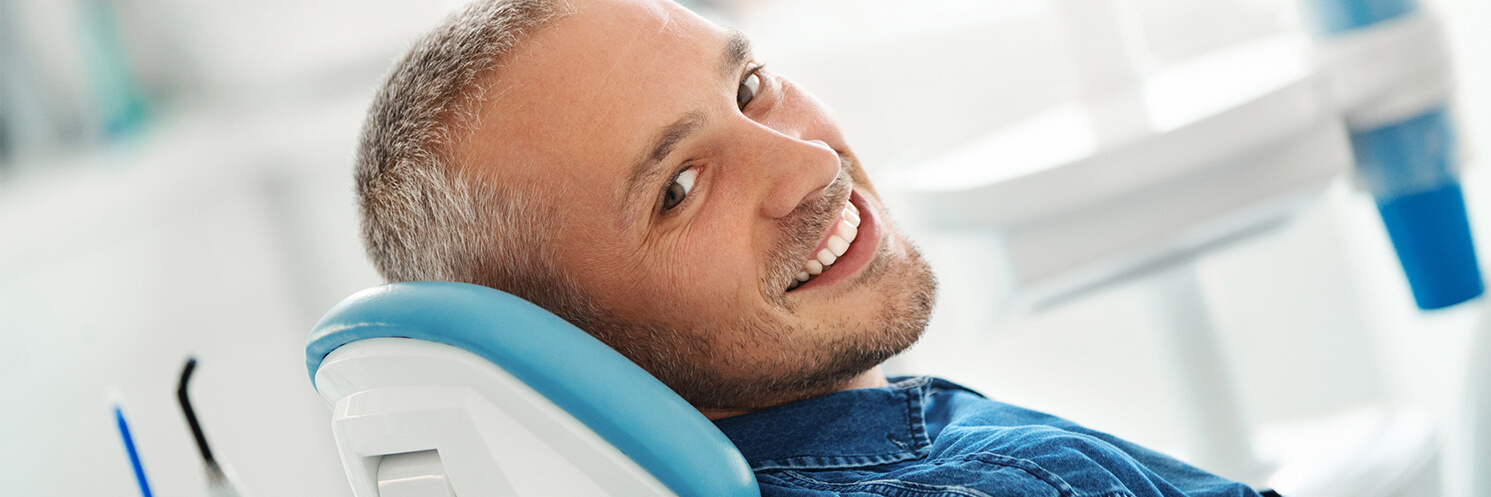 man smiling while waiting to see the dentist.