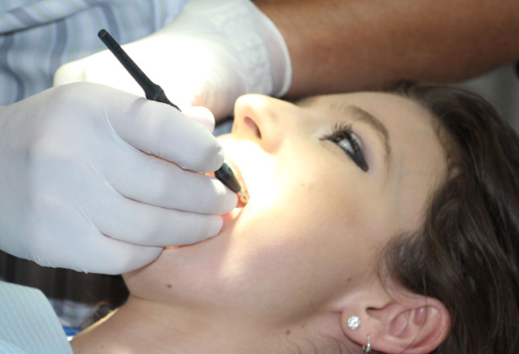 young woman getting a deep teeth cleaning at the dentist