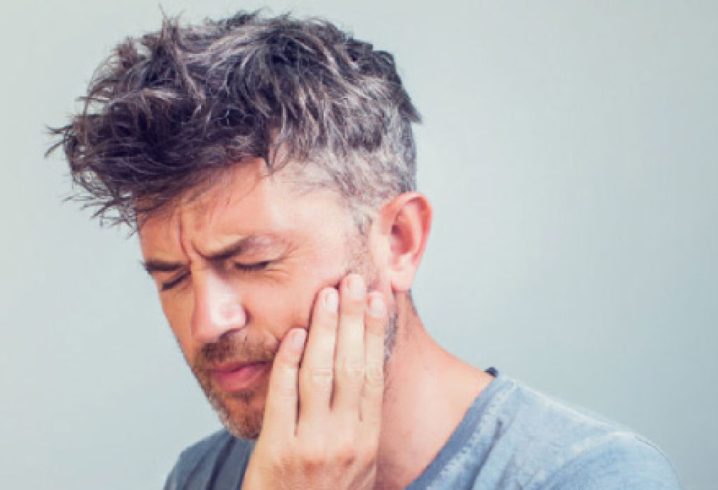 man holding his jaw with tmd pain