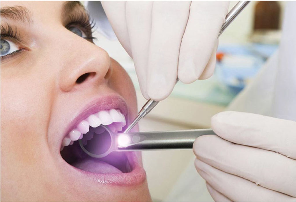 woman getting an oral cancer screening at the dentist