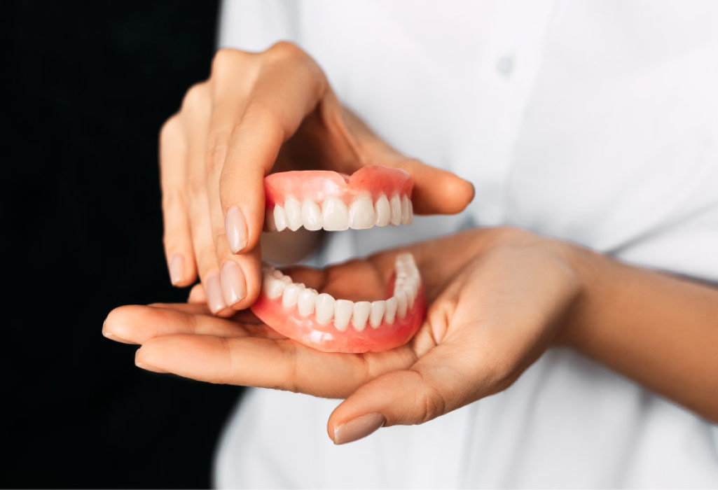 set of dentures held in two hands