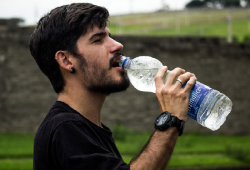 man drinking a big bottle of water