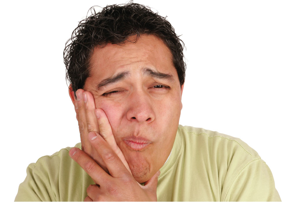 man holds a hand to his jaw and grimaces in pain with a toothache