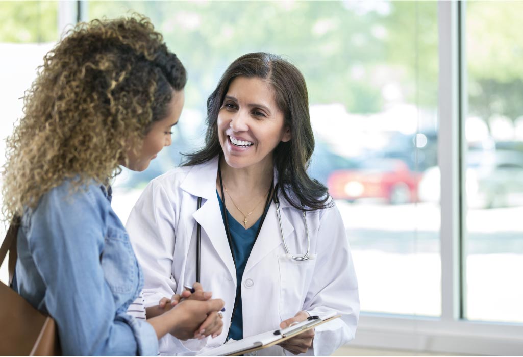 female dental worker greets a new female patient