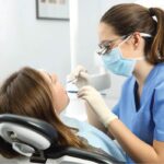 female patient gets checked for a loose dental implant