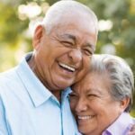 senior couple hug and smile after learning a denture options